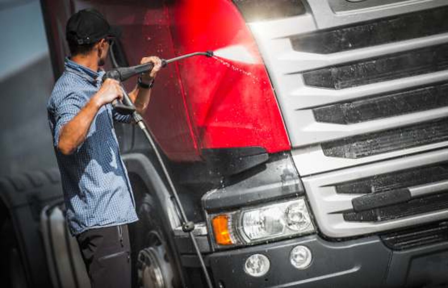 Truck being pressure washed in a wash bay